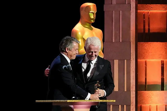 Hugh Grant, left, presents Richard Curtis with the Jean Hersholt Humanitarian Award during the 15th Governors Awards at The Ray Dolby Ballroom in Los Angeles