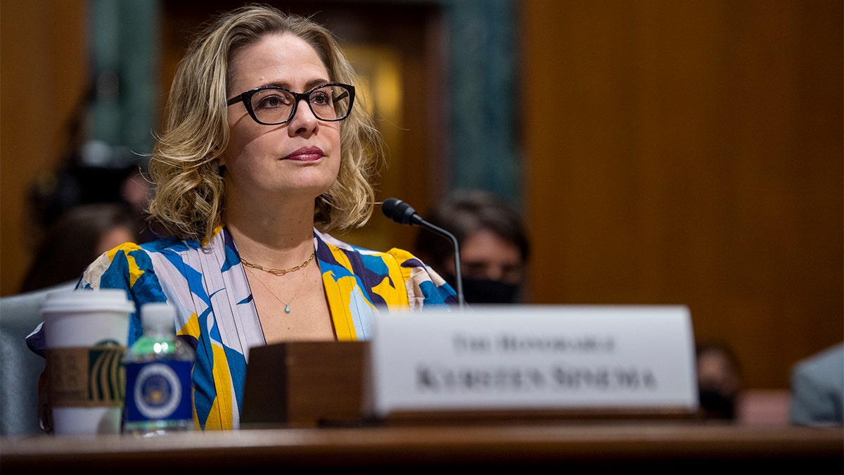 Sen. Sinema sitting at her seat at a Senate committee.