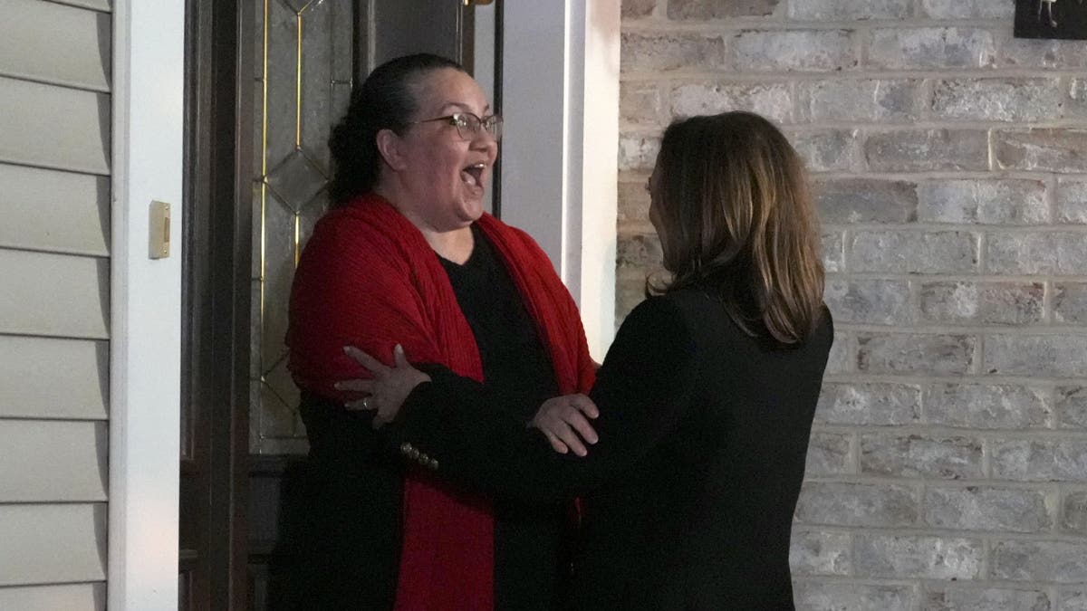 Harris embraces a woman while door knocking in Pennsylvania