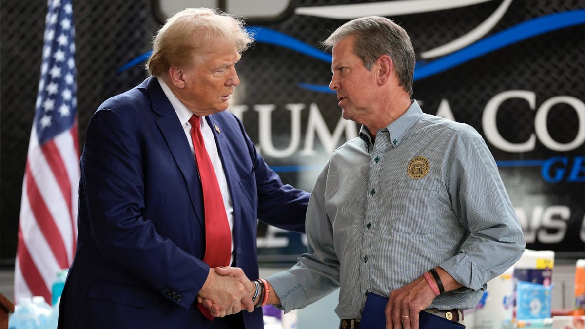 Republican presidential nominee former President Donald Trump shakes hands with Georgia Gov. Brian Kemp after speaking at a temporary relief shelter as he visits areas impacted by Hurricane Helene, Friday, Oct. 4, 2024, in Evans, Ga. (AP Photo/Evan Vucci)