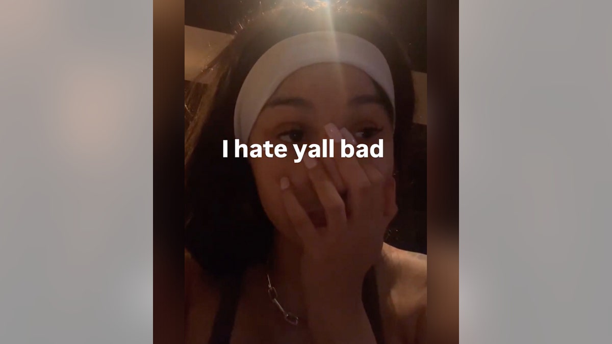 Cardi B wearing a white headband holds her hand to her mouth in an Instagram story