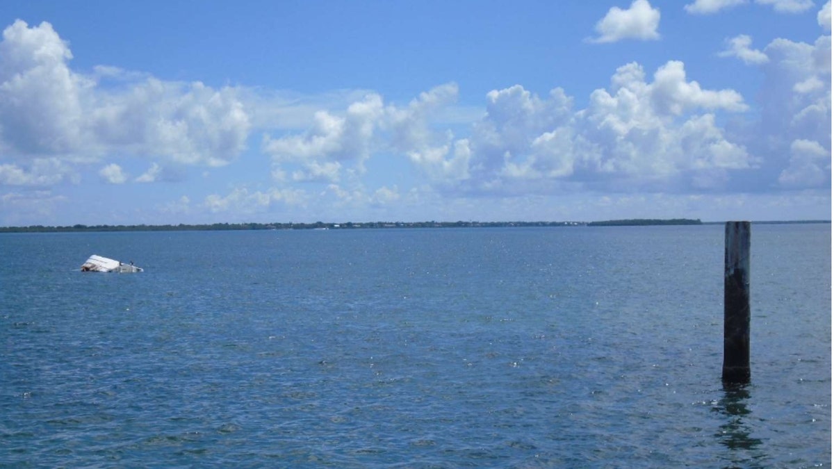 George Pino's capsized boat near a channel marker in the water