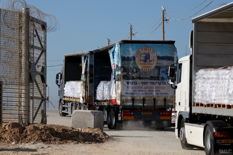 A truck carrying aid drives through a crossing.